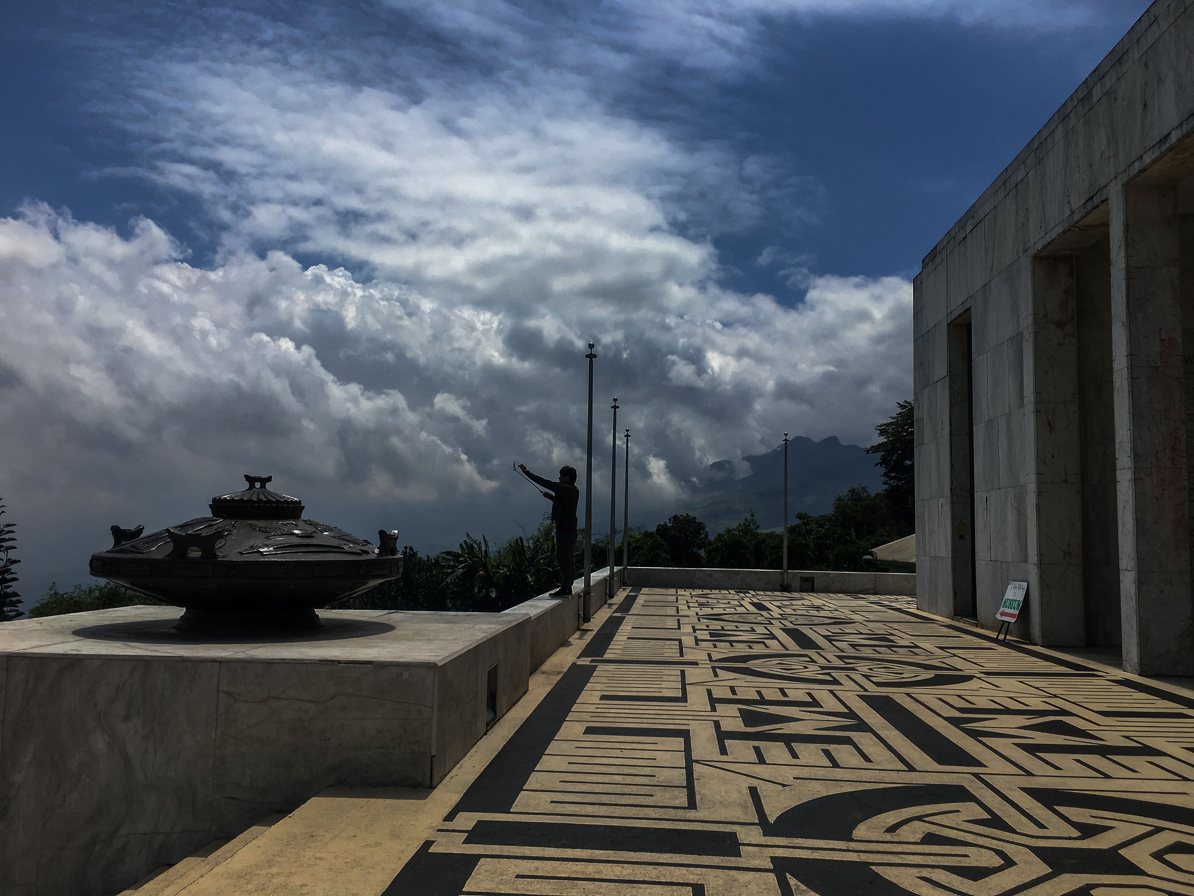 guy taking a picture at the collonade at the shrine of valor in bataan philippines